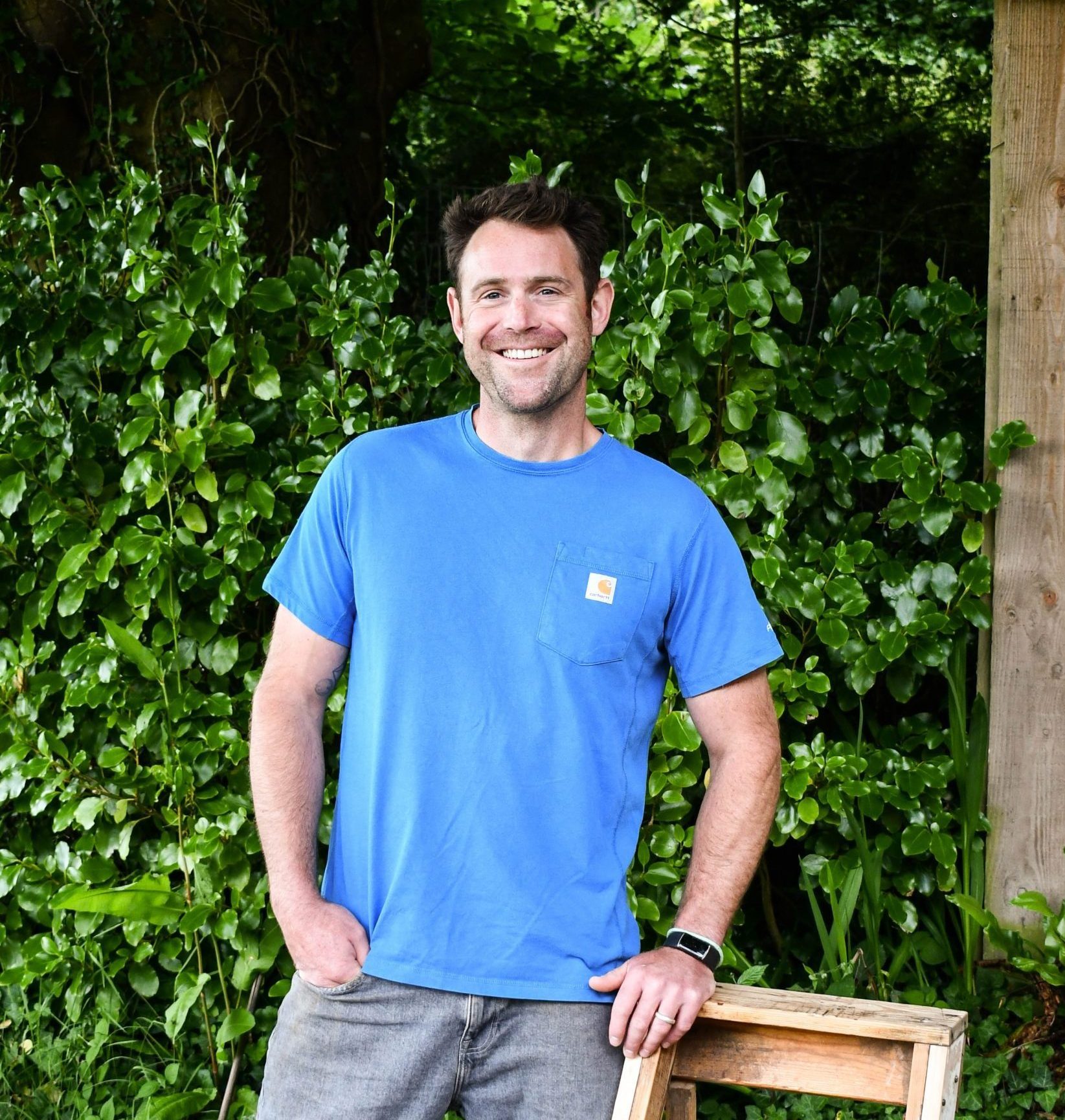 image of business owner Joe Colehan, smiling and leaning on a wooden ladder